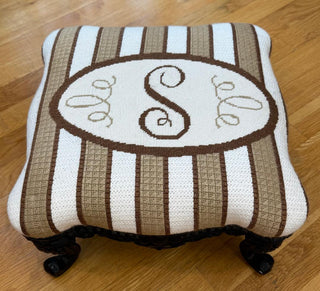 Needlepoint monogram finished as a footstool